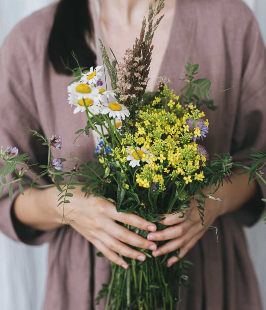 Kobieta trzymająca polne kwiaty