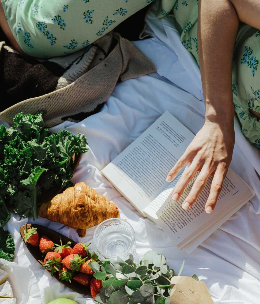 Osoba czytająca książkę na pikniku