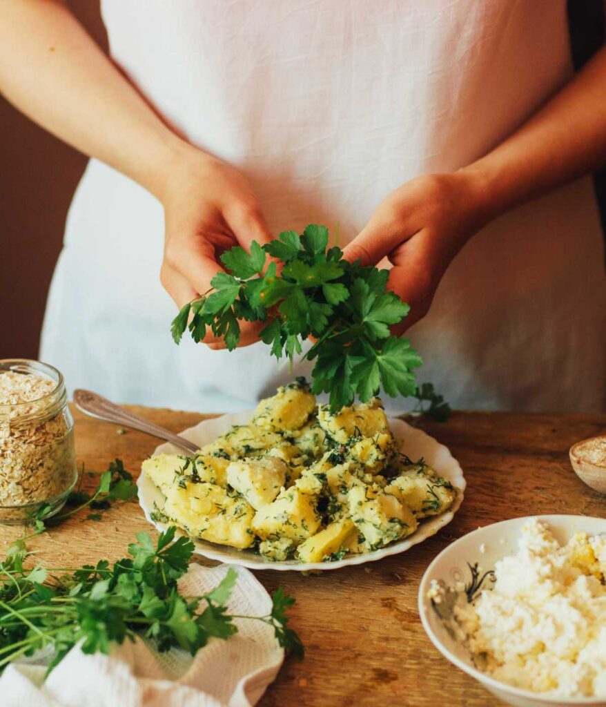 Osoba dekorująca jedzenie natką pietruszki